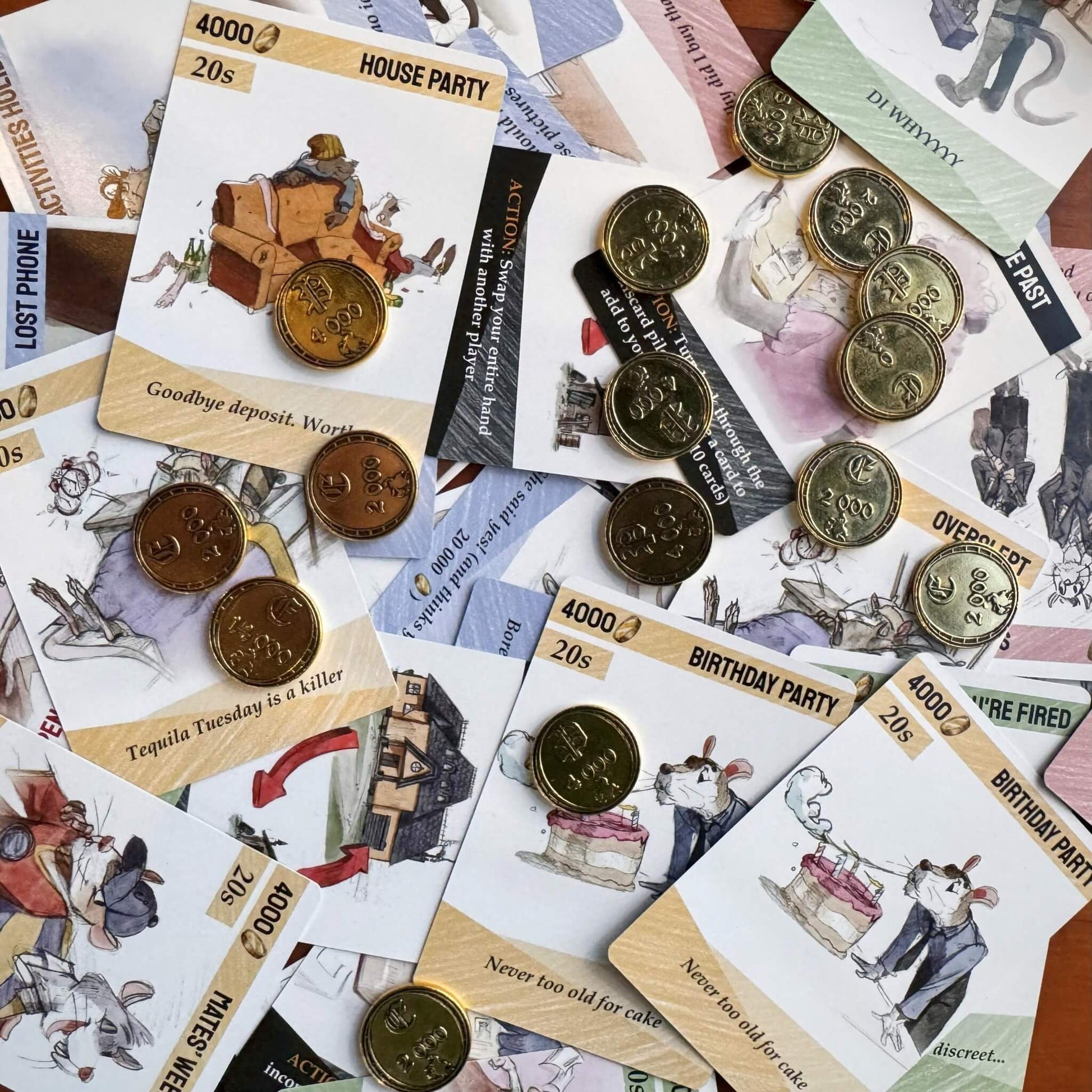 A close-up of the custom metal coins and beautifully illustrated cards from the premium Deluxe Edition of Escape The Rat Race.